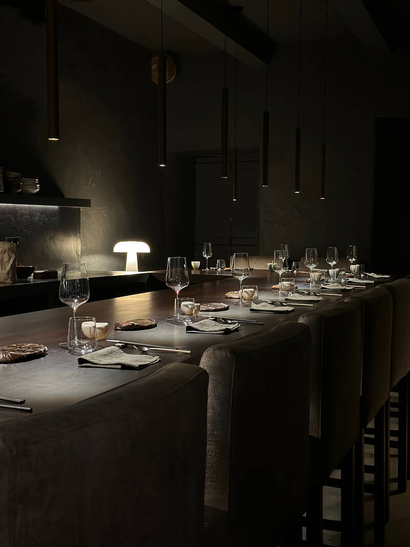 Balcão omakase com lugares postos e luz íntima