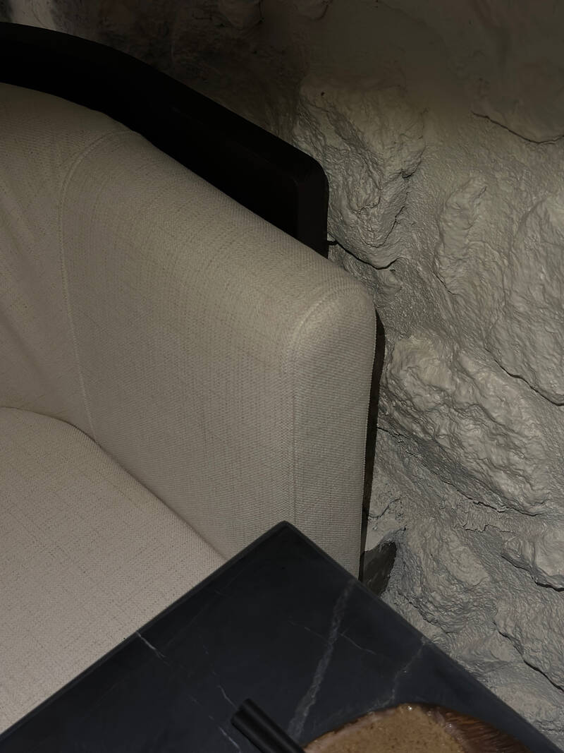 Detalhe de cadeira e parede de pedra caiada